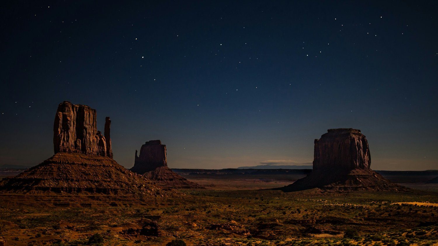 Desert buttes beneath a field of stars — the threshold of awakening
